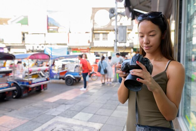 写真 街の通りに立っている若い女性