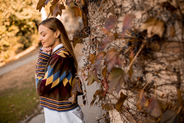 Young woman standing outside at sunny autumn day