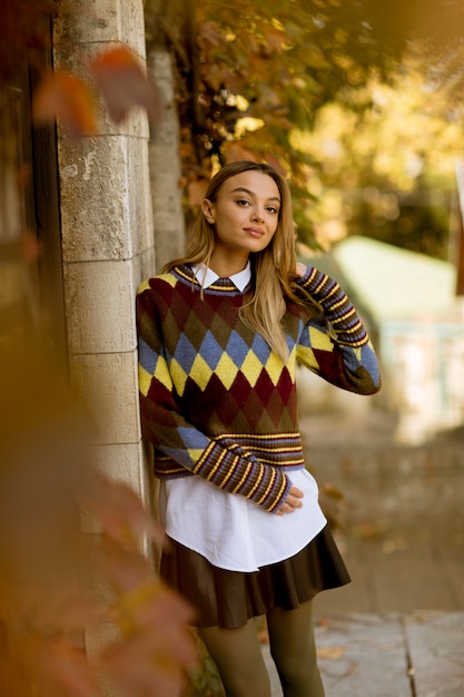 Young woman standing outside at sunny autumn day