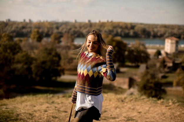 Young woman standing outside at sunny autumn day