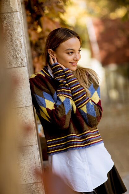 Young woman standing outside at sunny autumn day