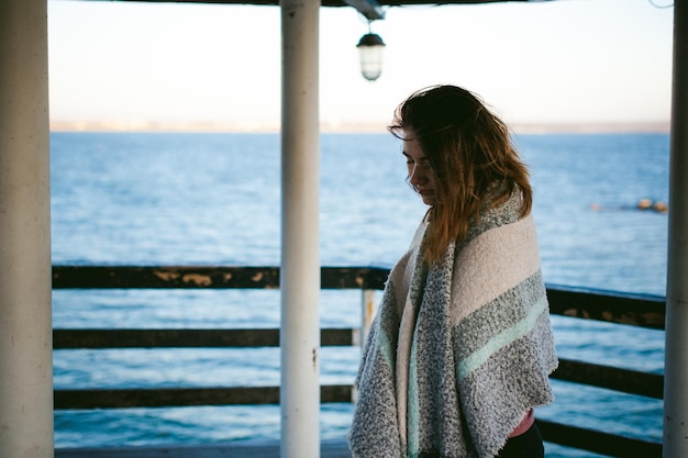 Foto giovane donna in piedi sul molo sopra il mare