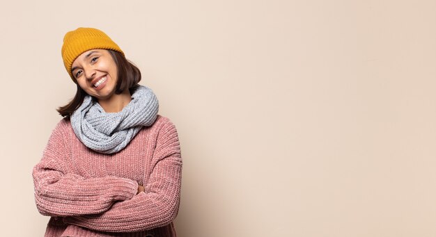 Young woman standing and pointing to object on copy space, rear view