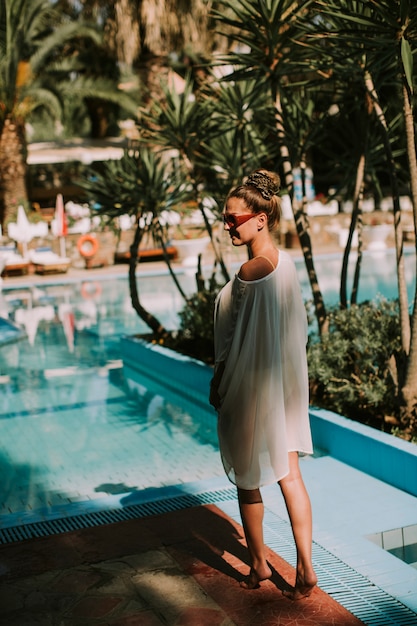 Foto giovane donna in piedi accanto alla piscina