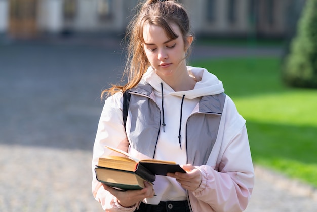 Young woman standing reading in warm evening light