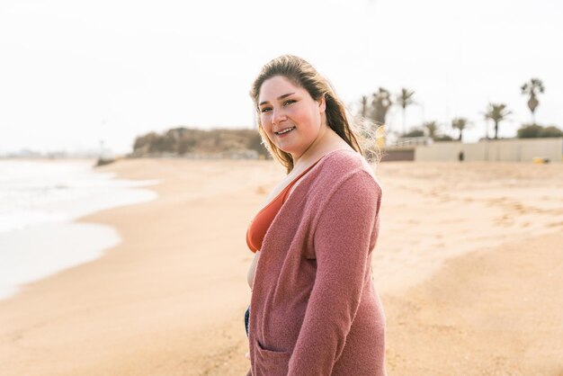 Young woman standing on sand against sky