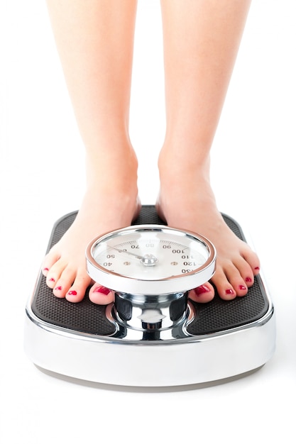 Photo young woman standing on a scale