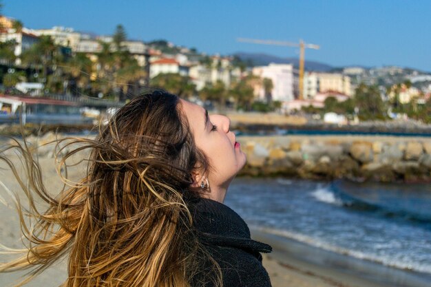 Young woman standing at shore while looking up