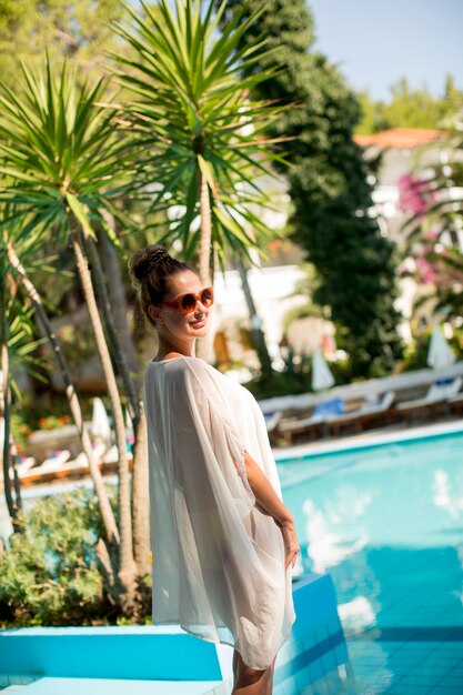 Photo young woman standing next to the swimming pool