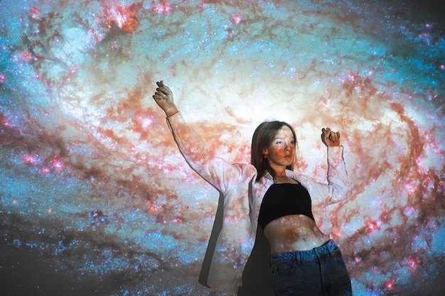 Photo young woman standing in universe texture projection