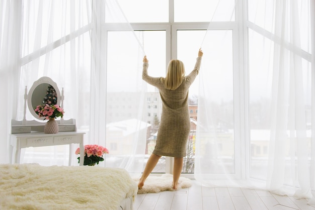 Young woman standing at the window