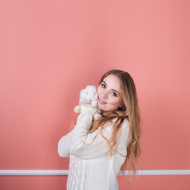 Foto giovane donna in piedi con coniglio carino