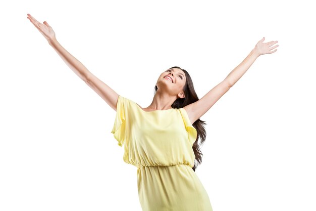 Young woman standing with open arms towards the sky