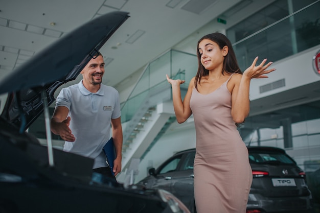 young woman stands near the car