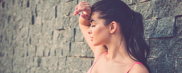 Foto la giovane donna sta vicino al muro