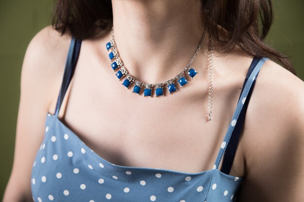 Young woman stands in a necklace