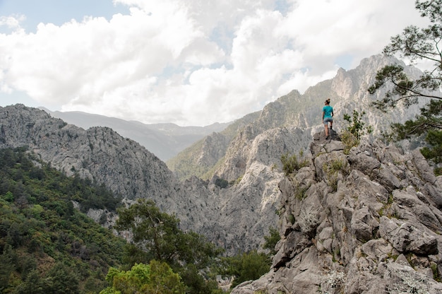 La giovane donna sta in cima alla montagna