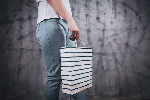 Young woman stands with gift bag