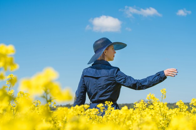 La giovane donna sta in un campo giallo