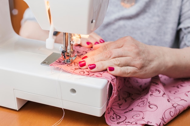 Фото Молодая женщина шить одежду на швейной машине