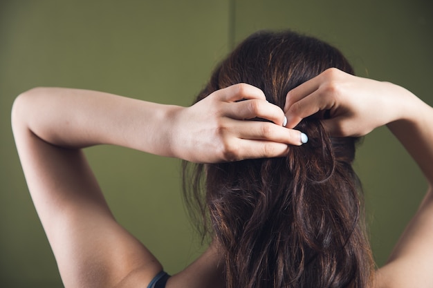 Young woman straightens her hair with her hands