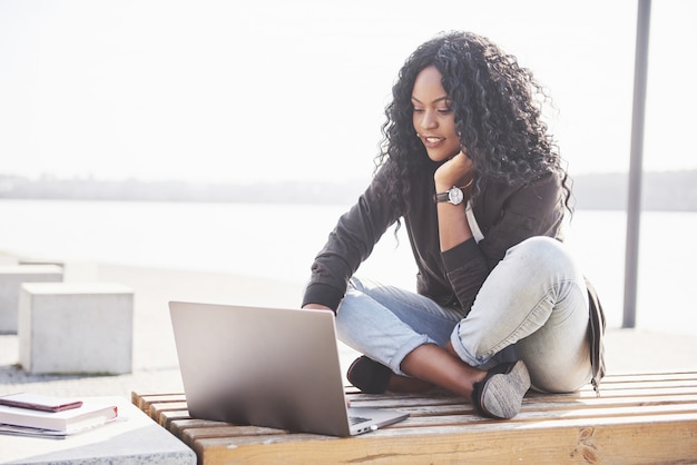 Young woman on the street working on laptop