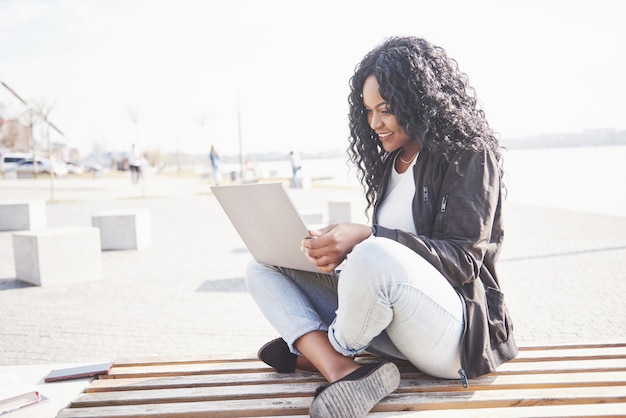 Young woman on the street working on laptop