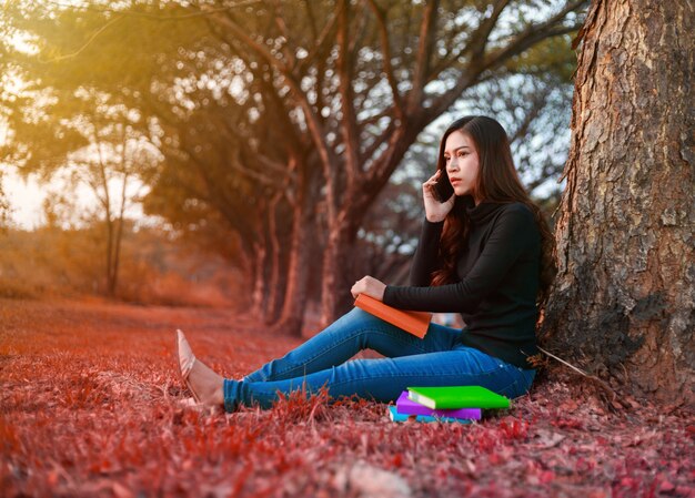 ストレス状況の若い女性は、公園の携帯電話で話すとき