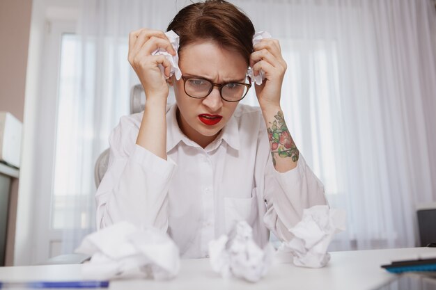 Young woman stressing out at work