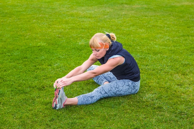 Young woman stretches her legs. Fitness. Healthy lifestyle.