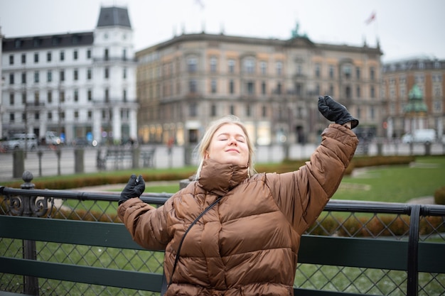 Young woman stretches and relaxes, it's winter, it's cold and she' wears gloves