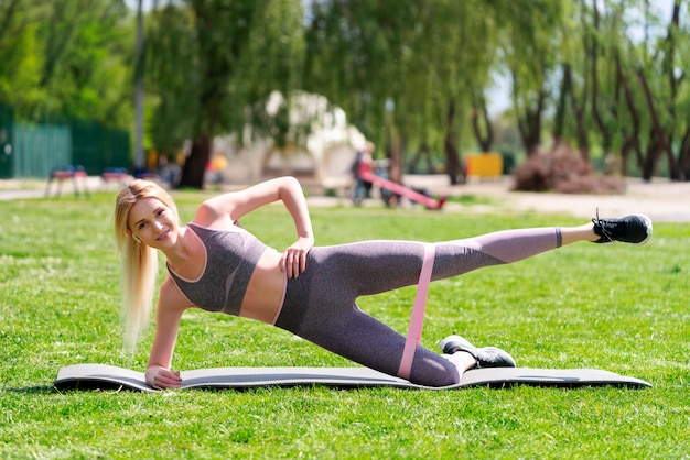 Young woman stretching doing leg swing outdoors