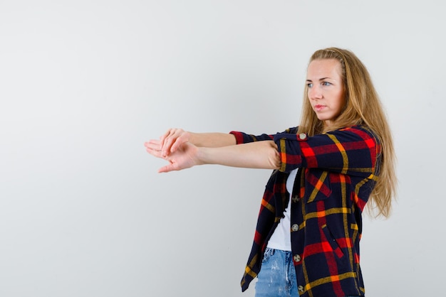 写真 白い背景の上の左に彼女の手を伸ばす若い女性