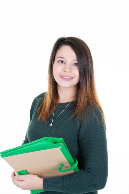 Young woman student holding folder in green sweater on white background