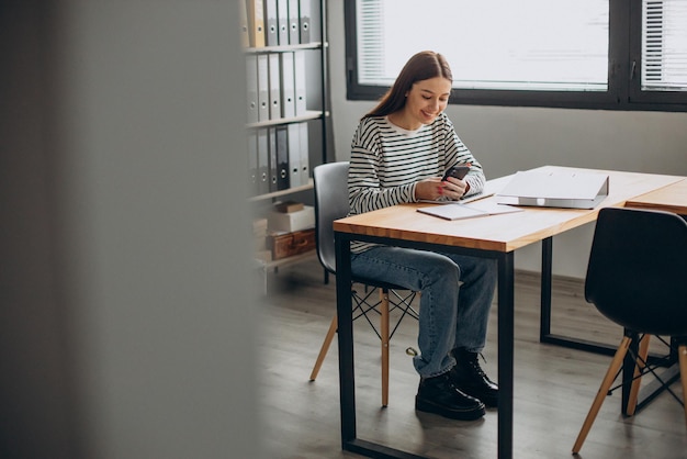 Giovane donna che studia in ufficio