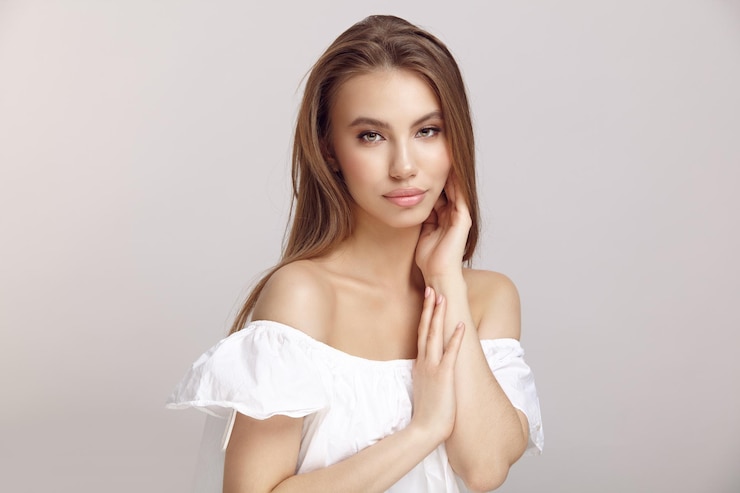 Photo young woman in stylish dress looks at camera in studio