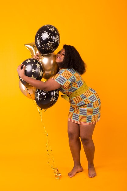 Young woman in stylish dress with balloons