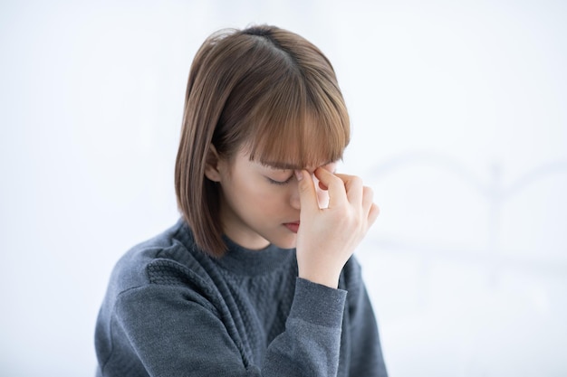 Young woman suffering from headache at home