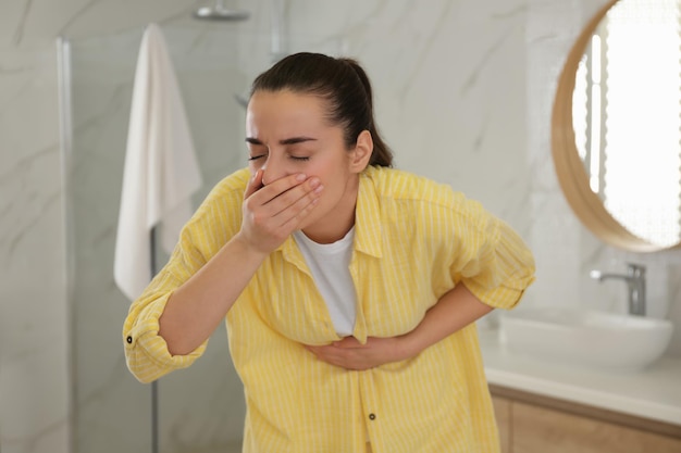 トイレで吐き気に苦しむ若い女性 食中毒