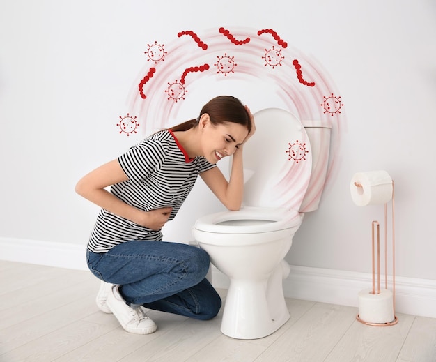 Young woman suffering from nausea at toilet bowl and bacteria illustration Food poisoning