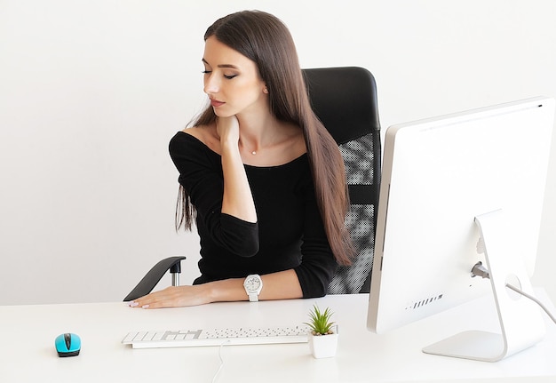 Young woman suffering from neck pain in office.