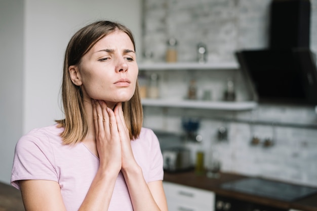 young woman suffering from throat pain
