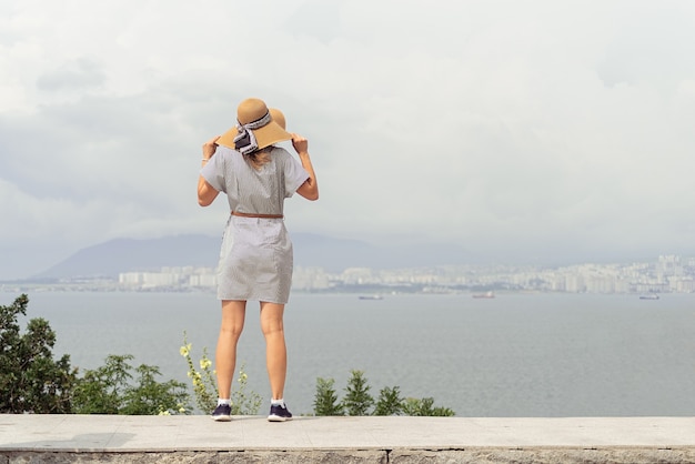 街並みを見ている夏のドレスの若い女性