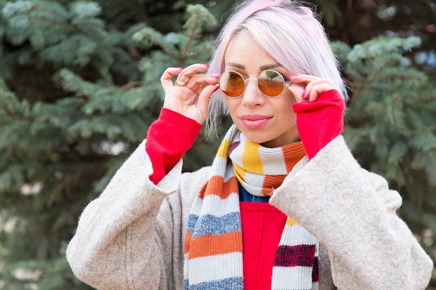 Young woman in sunglasses on a background of fir tree