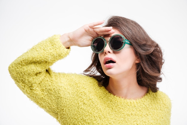 Young woman in sunglasses looking into the distance isolated on a white background