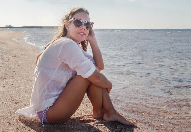 Young woman in sunglasses with developing hair smiling Concept