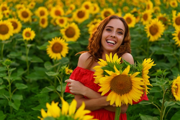 Young woman at sunset posing in a field of sunflowers freedom concept