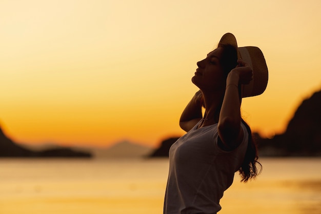 若い女性と湖の岸に沈む夕日