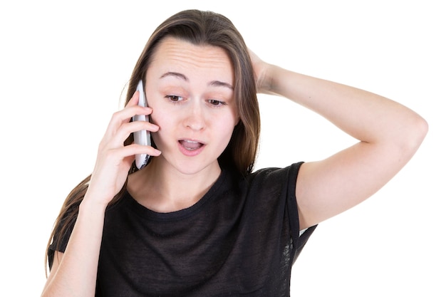 Young woman surprised talking on the phone on a yellow background