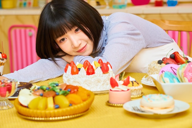 Foto una giovane donna circondata da dolci.